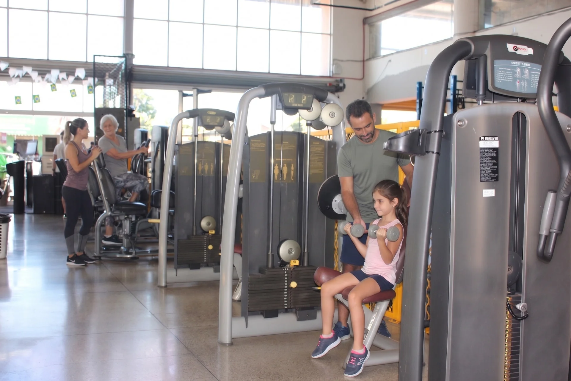Família treinando junto na área de musculação da Yellow Fit